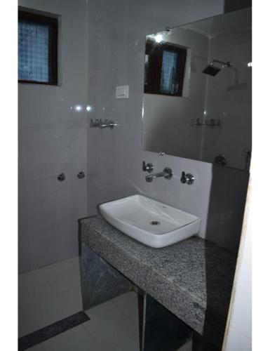 a bathroom with a white sink and a mirror at Hotel Royal sultan Resort, Pahalgam in Pahalgām