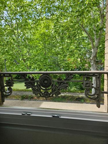 une fenêtre avec vue sur un parc arboré dans l'établissement Studio Luxine - 2 personnes - Vue sur le Canal du Midi, à Toulouse