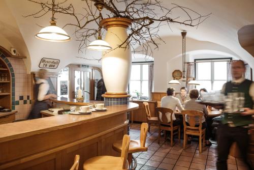 um restaurante com bar e pessoas sentadas a mesas em Gasthof Restaurant Zum Brauhaus em Hartberg