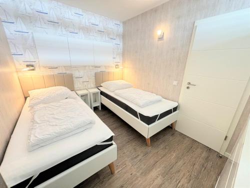 2 Betten in einem kleinen Zimmer mit in der Unterkunft Ferienpark Sierksdorf App 111 - Strandlage in Sierksdorf