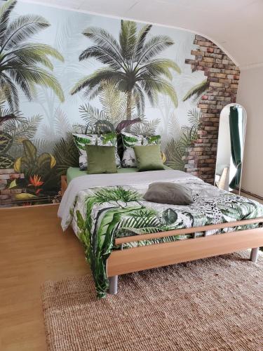 - une chambre avec un lit orné d'une fresque murale de palmiers dans l'établissement Physis, à Bogny Sur Meuse