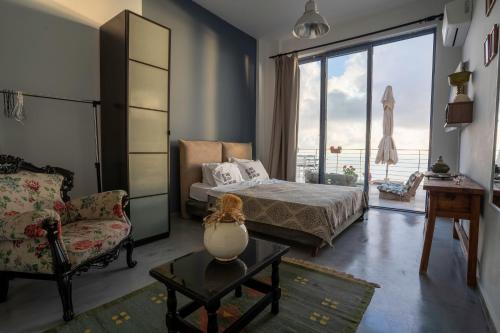 アサニオンにあるSerenity Boutique Suitesのベッドルーム1室(ベッド1台、椅子、窓付)