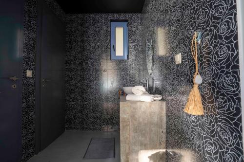 アサニオンにあるSerenity Boutique Suitesの洗面台と鏡付きのシャワーを備えたバスルーム
