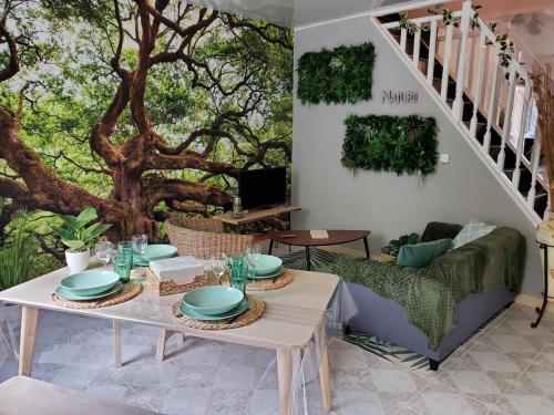 un salon avec une table et un arbre dans l'établissement Physis, à Bogny Sur Meuse