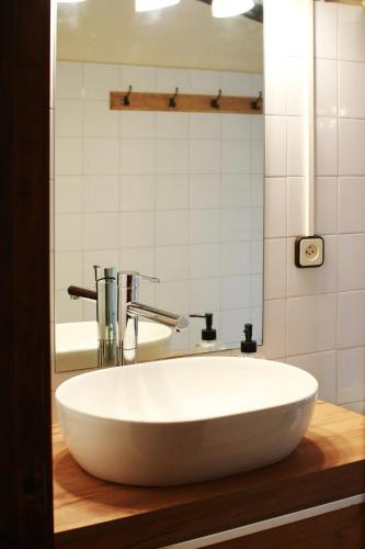 a white bowl sink on a wooden counter in a bathroom at El Celler de la Guàrdia in Montserrat