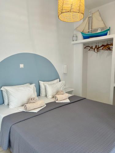 a bedroom with a blue bed with towels on it at Daphne in Naousa