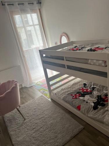 - une chambre pour enfants avec des lits superposés et une chaise dans l'établissement Appartement proche Stade de France Saint Denis, à Stains