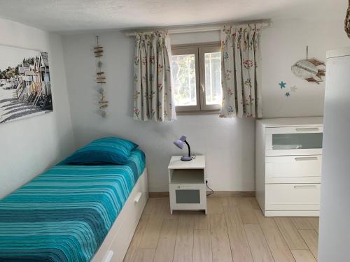 une petite chambre avec un lit et une table dans l'établissement Appartement rez de jardin de villa avec piscine, à Roquefort-les-Pins