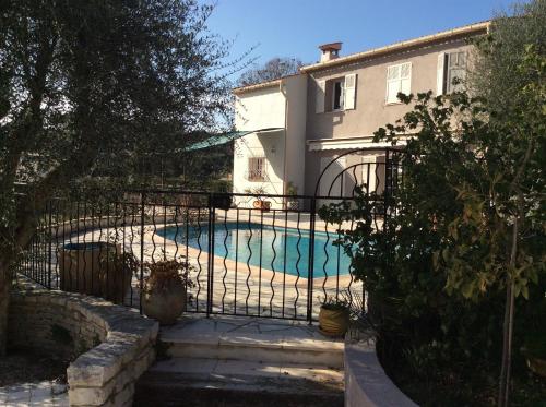une maison avec une piscine derrière une clôture dans l'établissement Appartement rez de jardin de villa avec piscine, à Roquefort-les-Pins