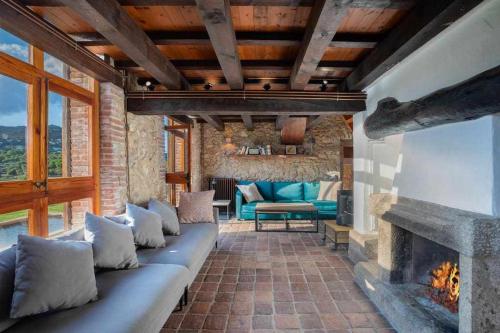 a living room with a couch and a fireplace at Mas Dels Arcs Con piscina Muy cerca de la playa in Calonge