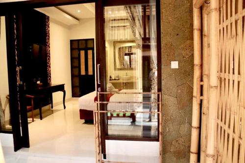 吉利特拉旺安的住宿－Vamana Resort - CHSE Certified，带一张床的卧室和玻璃门