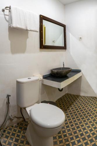 a bathroom with a toilet and a sink at Attara Inn Senggigi in Senggigi 