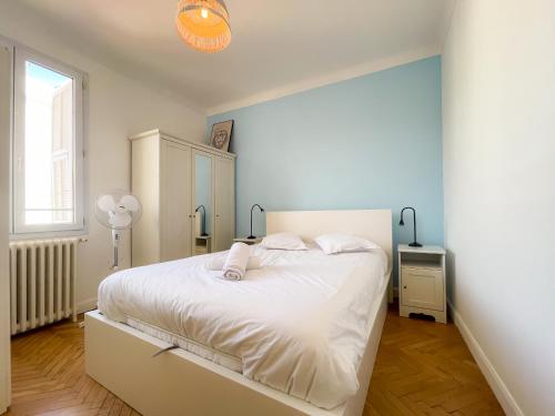 une chambre avec un lit blanc et une fenêtre dans l'établissement Gambetta, à Nice
