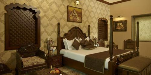a bedroom with a large bed and a chair at Neonz Resort & Club in Anand