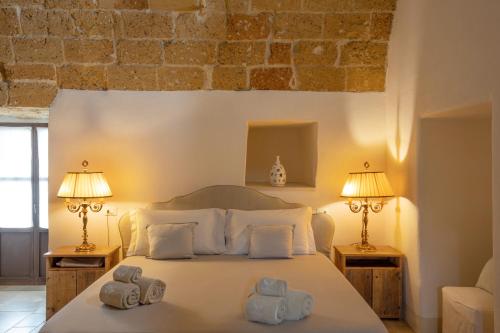 a bedroom with a bed with towels on it at Masseria Fano Relais & Wine in Salve