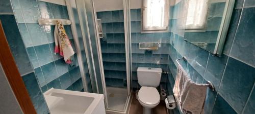 La salle de bains est pourvue de carrelage bleu, de toilettes et d'un lavabo. dans l'établissement Appartement 2 pièces à Saint Aygulf-Fréjus, à Fréjus