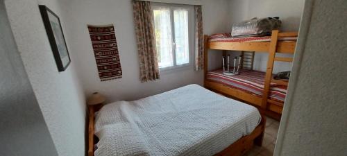 Cette petite chambre comprend des lits superposés et une petite table. dans l'établissement Appartement 2 pièces à Saint Aygulf-Fréjus, à Fréjus