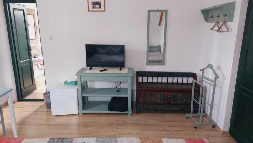 a room with a table with a television and a crib at Pensiunea Királylány Vendégház in Rimetea