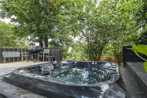 a metal tub in a yard with a grill at The Ridge London - Luxury Designer Villa with hot tub and sauna, Bexley borough of London in London