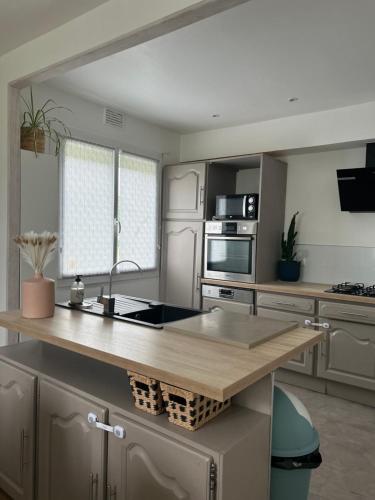 - une cuisine avec îlot central et comptoir dans l'établissement Maison 3 chambres, piscine, à Tonneins