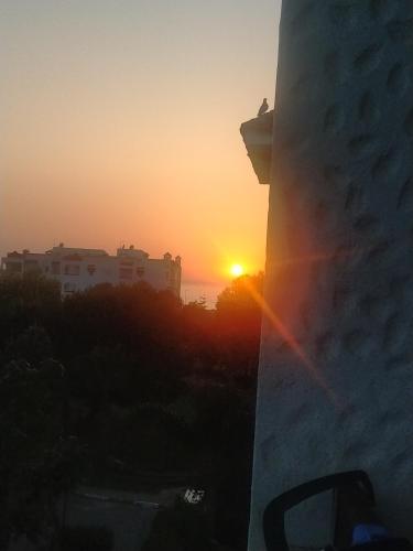a sunset from a building with the sun setting in the distance at assilah marina golf assilah in Asilah