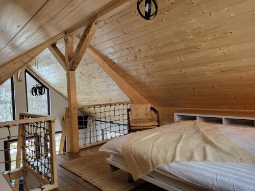 a bedroom with a bed in a room with wooden ceilings at Refugiul din Vama in Vama Buzăului