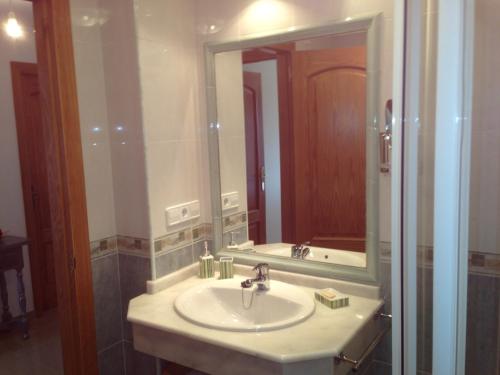 a bathroom with a sink and a large mirror at Apartamento en A Revolta, Sanxenxo in Sanxenxo