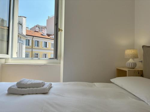a bedroom with a white bed and a window at Il Sigillo in Trieste