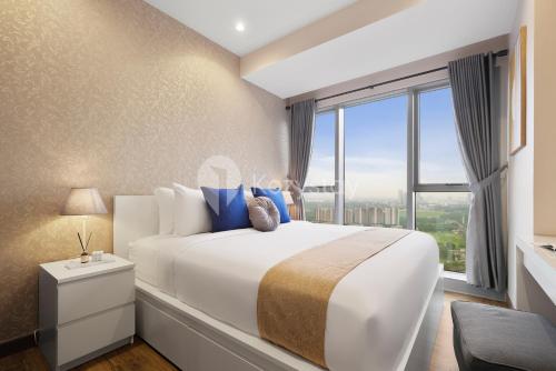 a bedroom with a large bed with a large window at Serei by Kozystay - BSD in Tangerang