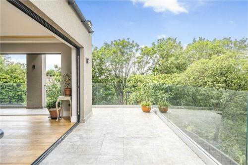 an open patio with potted plants and an open door at The Ridge London - Luxury Designer Villa with hot tub and sauna, Bexley borough of London in London