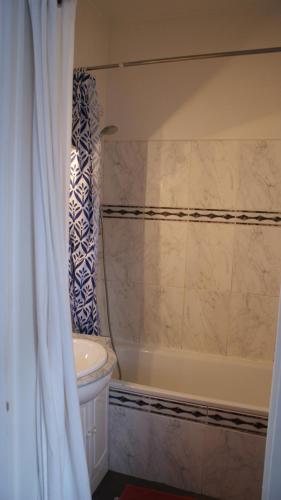La salle de bains est pourvue d'une baignoire, de toilettes et d'un rideau de douche. dans l'établissement Calme et charmant appartement près de Paris et Versailles, à Le Vésinet