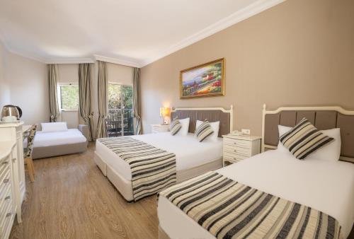 una camera d'albergo con due letti e due finestre di Crystal Tat Beach Golf Resort & Spa - Ultimate All Inclusive a Belek