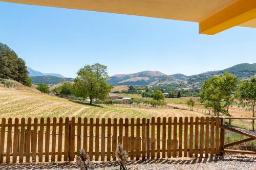 a fence in front of a hill with mountains in the background at Rifugio La PRINCIPESSA in Morano Calabro
