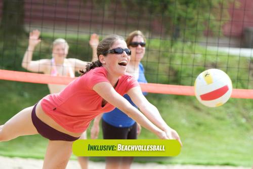 a woman hitting a volley ball during a game at AHORN Waldhotel Altenberg in Kurort Altenberg