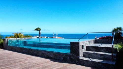 a swimming pool with the ocean in the background at The Urban Retreat by LovelyStay in Funchal