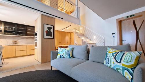 a living room with a blue couch and a kitchen at The Urban Retreat by LovelyStay in Funchal