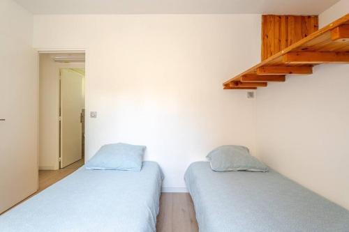 two twin beds in a room with a staircase at Maison de vacances Marseille in Marseille