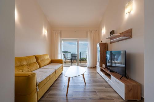 a living room with a couch and a television at Golden View Apartments in Zelenika
