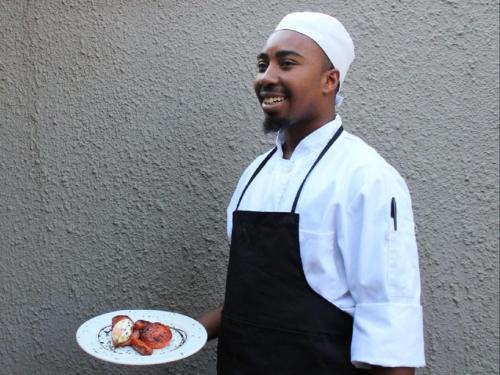 a man is holding a plate of food at Vista ORT in Kempton Park