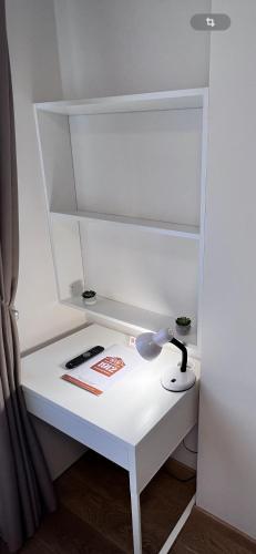 a white desk with a lamp on top of it at 1912 Bed & Breakfast in Klaipėda