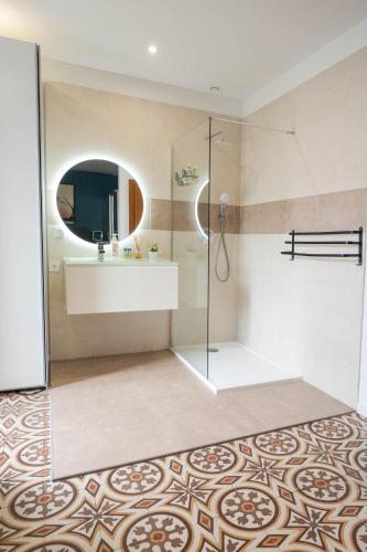 une salle de bain avec une douche, un lavabo et un miroir dans l'établissement Les Arènes Wi-Fi Climatisation Jardin Netflix 10 mn cœur de ville, à Béziers