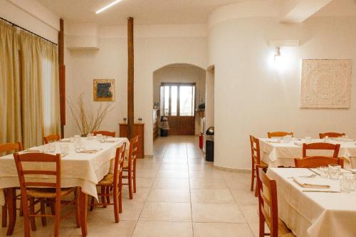 a dining room with white tables and chairs and a hallway at Rifugio La PRINCIPESSA in Morano Calabro