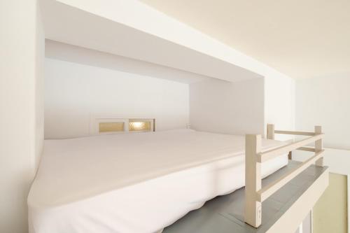 - une chambre blanche avec un lit et une étagère dans l'établissement Residence les palombes, à Nice