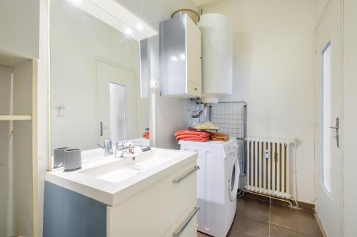 une salle de bain blanche avec un lavabo et un miroir dans l'établissement Residence les palombes, à Nice