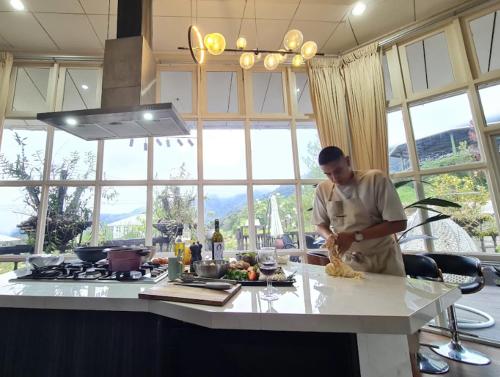 a man in a kitchen preparing food on a counter at La Cantane Villa in Kundasang
