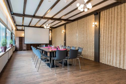 a conference room with a table and chairs and a projection screen at Het Wapen van Elst in Elst
