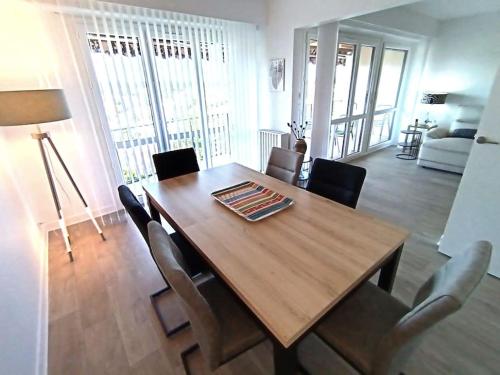 une salle à manger avec une table et des chaises en bois dans l'établissement Appartement spacieux avec terrasse en plein centre, à Anglet