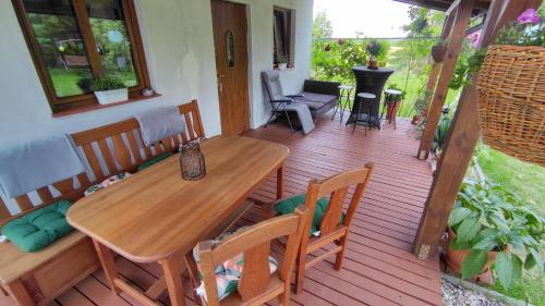 a wooden deck with a wooden table and chairs at Domek w Sadzie in Marcinowa Wola