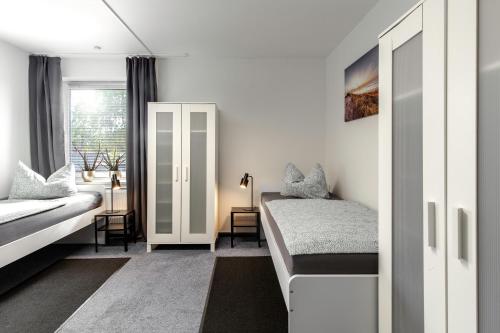 a bedroom with a bed and a desk and a window at Ferienwohnung Arkadia Zentrale in Norderstedt