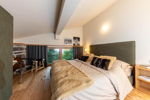 a bedroom with a large bed with a large blanket at Villa Speronella in San Martino di Castrozza